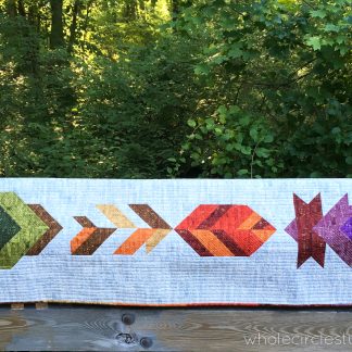 A fun, modern autumn wall hanging quilt or table runner! Leaf Peepers is a modern spin on the traditional half square triangle block. Join the sew along and quilt along and make this for your home or as a gift for Thanksgiving! Leah Day and Whole Circle Studio will walk you through all of the steps of this PDF pattern on their blogs. Add additional background fabric to make a larger quilt!