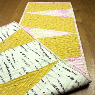 Dress up your table with this reversible, easy to make runner! Piece and quilt with the supplied templates. Makes a great hostess gift! Designed by Whole Circle Studio.