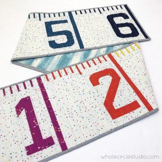 Make this easy foundation paper piecing (FPP) quilt — a tape measure quilt/runner. It also makes a fun table or bed runner. Make one as a gift a tinkerer, teacher, kid, or baby as a wall hanging or growth chart. PDF pattern
