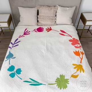 bed with rainbow, colorful botanical themed quilt