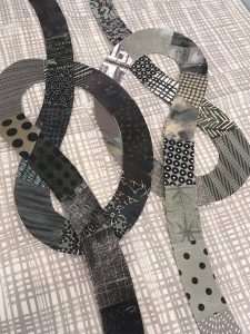 quilt block with gray knots intertwined on a gray and white background