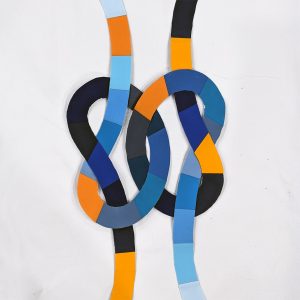 quilt block with orange and blue segmented knots intertwined on a striped black and white background