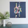 quilt of two colorful knots interlocking on a blue background hanging on a wall