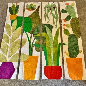 four plant themed quilted wall hangings