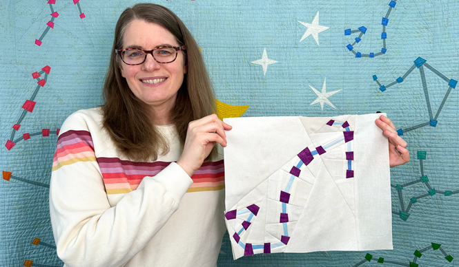 woman holding a Scorpio constellation zodiac star quilt block