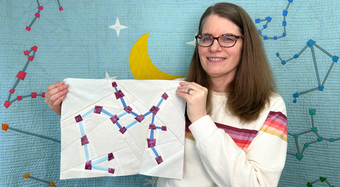 woman holding a Sagittarius constellation zodiac star quilt block