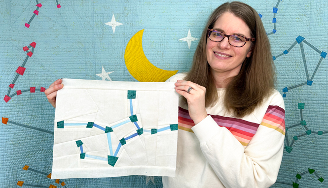 woman holding a Virgo constellation zodiac star quilt block