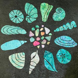 Turquoise seashell and colorful batik sea glass quilt made with the Shoreline Shells quilt pattern.