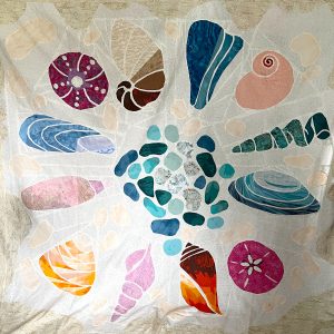 Scrappy seashell quilt using assorted fabrics and the Shoreline Shells quilt pattern.
