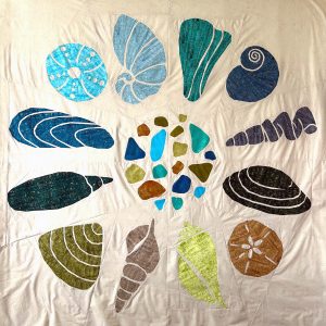 Scrappy seashell quilt using assorted fabrics and the Shoreline Shells quilt pattern.