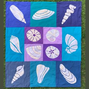 Blue, Purple, and off-white seashell quilt made with the Shoreline Shells Block of the Month pattern.