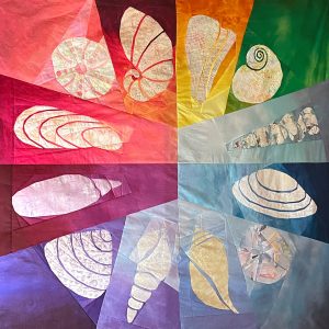 Rainbow seashell quilt made from the Shoreline Shells quilt pattern by Whole Circle Studio.
