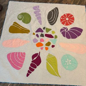 Rainbow seashell quilt made from the Shoreline Shells quilt pattern by Whole Circle Studio.