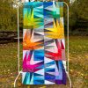 scrappy quilt top runner using colorful fabric hanging outside
