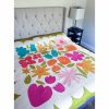 Bright, colorful flower handmade quilt on a bed