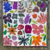 colorful scrappy flower modern quilt hanging on a fence