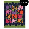 Colorful modern flower quilt blocks made into a Twin Size quilt on a navy blue background and green border