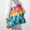 woman holding a tote bag with a colorful sunset
