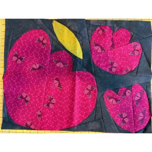 bright colorful flower quilt block on a cutting mat