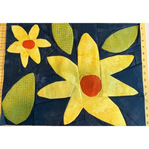 modern flower quilt block made with yellow, orange, and green fabrics