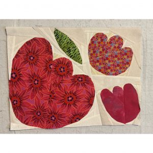quilt block with three red flowers made with red print fabric