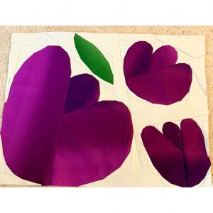 three foundation paper pieced flowers made using purple fabric