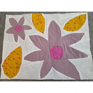 Modern floral quilt block in muted colors and bright yellow floral fabric