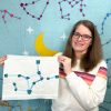 woman holding a paper pieced virgo constellation quilt block
