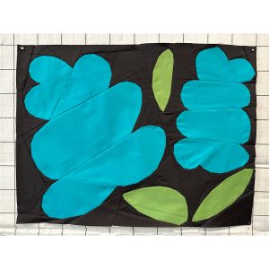 large foundation paper pieced flower quilt block made with blue, green, and black fabrics
