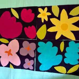 4 colorful flower quilt blocks on a wall