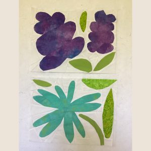 two flower quilt blocks made with purple, aqua, and green batik fabric on a white background