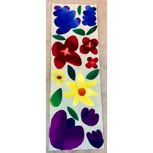row of colorful flower quilt blocks made with floral fabric and scraps of white fabric