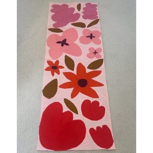 row of purple, pink, orange, and red flower quilt blocks on a pink background