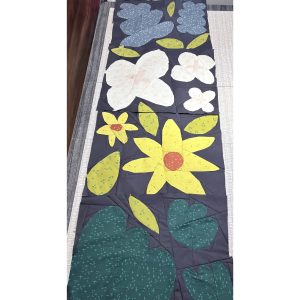 row of colorful flower quilt blocks made with floral fabric on a gray background fabric