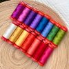 15 colorful spools of thread on a wooden plate