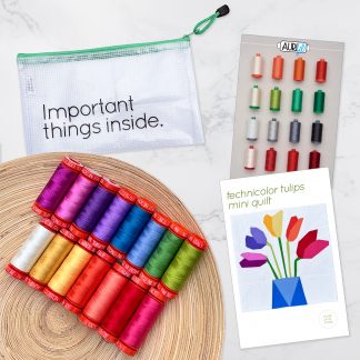 15 colorful spools of thread on a wooden plate, pouch that says Important Things Inside, thread booklet, and quilt pattern