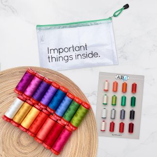 15 colorful spools of thread on a wooden plate, pouch that says Important Things Inside, and thread booklet
