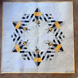 Modern quilt featuring large stylized bees in a graphic contemporary design.