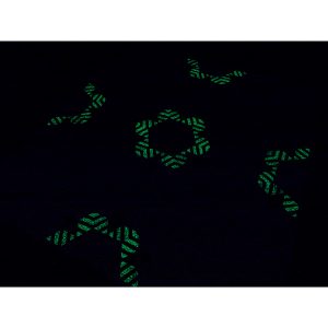 lights off featuring glow in the dark fabrics and large quilt made from repeating bee blocks arranged in a modern geometric layout.