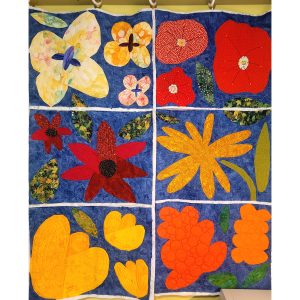 Modern floral quilt blocks in progress arranged on a design wall.